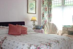 a bedroom with a bed and a chair and a window at Knightsrest in Burnham on Sea
