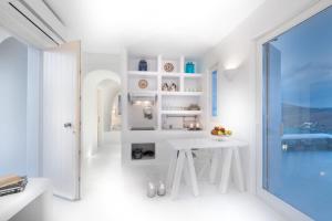 a white room with a white table and a window at Astrini in Kithnos
