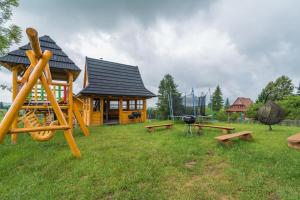 a log cabin with benches and a playground at Pokoje u Bobików in Ząb