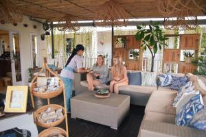 un groupe de personnes assises dans un salon dans l'établissement Pesona Beach Resort & Spa, à Gili Trawangan