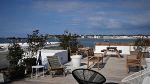 una terraza con sillas y mesas y vistas al agua en Belarra, en Ciboure