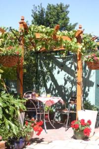 a pergola with a table and chairs and flowers at Knightsrest in Burnham on Sea