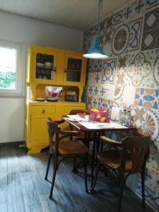 uma cozinha com armários amarelos, uma mesa e cadeiras em A Tasca em Vila Real