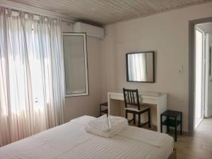 - une chambre avec un lit, une chaise et un bureau dans l'établissement Home by the sea, à Monemvasia