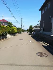 an empty street with a man hole in the middle at Jukichi Owada Residence Twin Room in Sendai