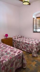 カサジャ・デ・ラ・シエラにあるColonia de Galeón nº 71のベッドルーム1室(ベッド2台、ランプ付きテーブル付)