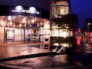 a building on a city street at night with lights at Hotel AreaOne Chitose in Chitose