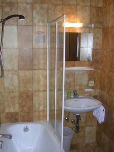 y baño con ducha, bañera y lavamanos. en Köflerhof Appartements, en Sankt Leonhard im Pitztal