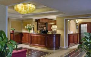 a woman sitting at a desk in a lobby at Corona D'Italia in Florence