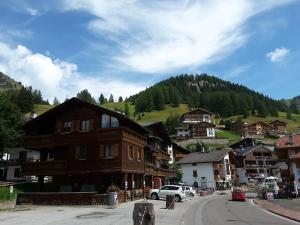 a town in the mountains with a car parked on the street at Chalet Helen in Arabba