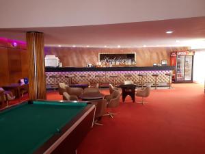 a pool table in a room with a bar at Hotel Scoica in Jupiter