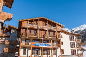 a large wooden building with balconies on it at Résidence Les Balcons de Val Cenis Village in Lanslevillard