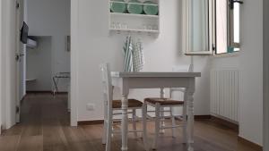 una mesa y sillas blancas en una habitación con paredes blancas en La Dimora dei Sorrisi, en Monopoli
