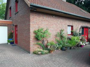 a brick building with a bunch of potted plants on it at Apartment am Park - Erica in Schneverdingen