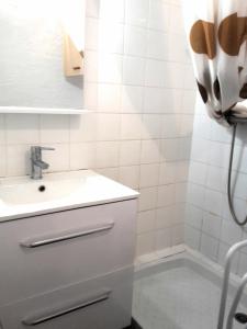 a white bathroom with a sink and a shower at Leucate,dans la verdure,studio caverne en pierre dans propriété sécurisée in Leucate