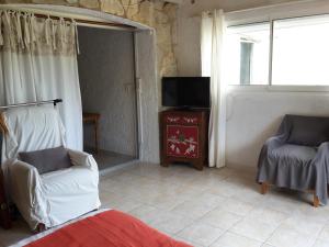 a living room with two chairs and a television at Leucate,dans la verdure,studio caverne en pierre dans propriété sécurisée in Leucate
