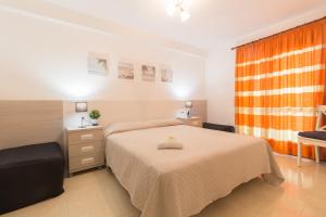 サロウにあるMalvinas IBERPLAYAのベッドルーム1室(ベッド1台、オレンジ色のカーテン付)