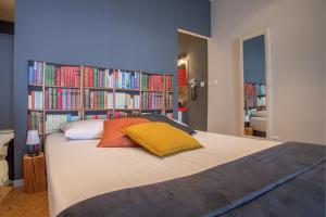 Chambres d'hôtes L'Ecrit Vin في Rustiques: غرفة نوم بسرير كبير مع ارفف كتاب مليئة بالكتب