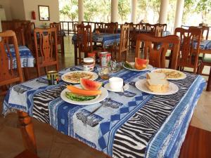 einem blauen und weißen Tisch mit Teller mit Lebensmitteln darauf in der Unterkunft Voyage Village in Mikumi