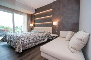 a hotel room with a bed and a couch at Hotel Giulietta Romeo in Lazise +37 photos