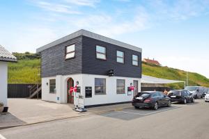 una casa en blanco y negro con coches aparcados en un estacionamiento en B&B Wharfside Hirtshals, en Hirtshals