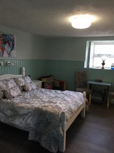 a bedroom with a large bed and a window at Mill Cottages in Kesh