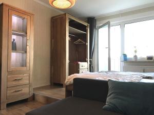 ケムニッツにあるApartment Annaのベッドルーム1室(ベッド1台付)、木製キャビネットが備わります。