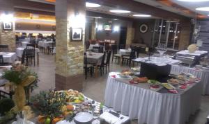 a dining room with tables with plates of food at Apartment G10 Milmari resort in Kopaonik