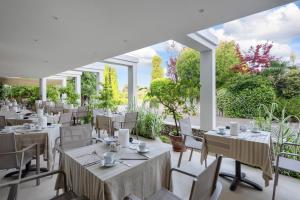 un restaurante con mesas y sillas blancas y vistas en Hotel Giulietta Romeo, en Lazise