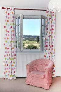 a living room with a chair and a window at Manoir Le Mesnil in Saint-Martin-aux-Chartrains