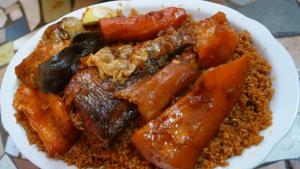 un piatto di cibo con carote e riso su un tavolo di Campement & Centre artistique Tilyboo a Kafountine