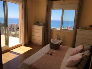 sypialnia z łóżkiem i widokiem na ocean w obiekcie Rooms in Seafront Villa w Maladze
