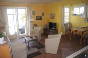 a living room with white chairs and a table at Über dem Meer in Lohme