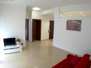 カステッランマーレ・デル・ゴルフォにあるAppartamenti Manzoniのリビングルーム(赤いソファ、テレビ付)