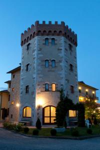 a large brick building with a clock on the front of it at Albergo La Lanterna in Sarteano