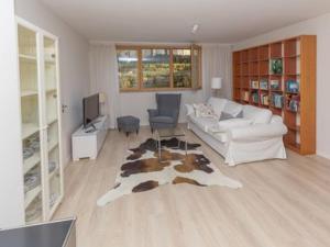ein Wohnzimmer mit einer weißen Couch und einem Kuhteppich in der Unterkunft Kügelgenstraße 1 in Dresden