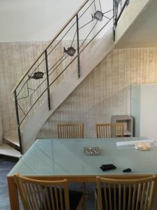 einen Esstisch mit Stühlen und eine Treppe in der Unterkunft Duplex Bord Bassin d'Arcachon in Arès