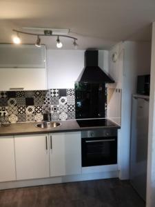 a kitchen with white cabinets and a sink at Duplex Bord Bassin d'Arcachon in Arès