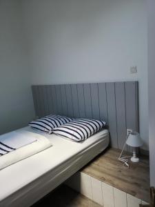 ein großes Bett mit grauem Kopfteil in einem Schlafzimmer in der Unterkunft Duplex Bord Bassin d'Arcachon in Arès