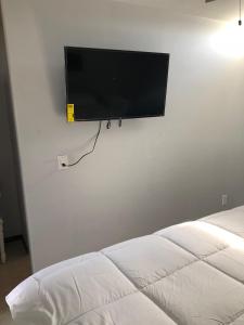 a flat screen tv hanging on a wall next to a bed at Conjunto Ballena Townhouses in Puerto Peñasco