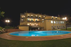 a large building with a swimming pool at night at Albergo La Lanterna in Sarteano