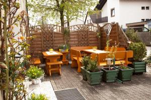 eine Terrasse mit Tischen, Stühlen und Topfpflanzen in der Unterkunft Hotel Drei Löwen in Dachau