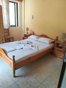 a bedroom with a bed with white sheets and a window at Poulithra Beach in Poulithra