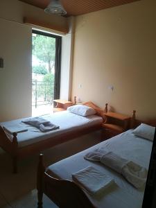 two beds in a room with a window at Poulithra Beach in Poulithra