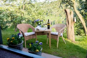 una mesa con una botella de vino y dos sillas en GoldenValley Shepherd's Hut en Dorstone