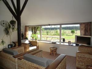 a living room with chairs and a flat screen tv at de Kruik in Blesdijke