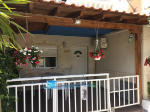 a porch with a white fence and flowers at Hotel Alexandros II in Toroni