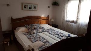 エンプリアブラバにある010 Segre casa con piscina y amarreのベッドルーム1室(木製ヘッドボード付きのベッド1台付)