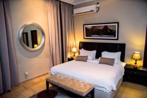 a bedroom with a large white bed and a mirror at Clear Essence California Spa & Wellness Resort in Lagos