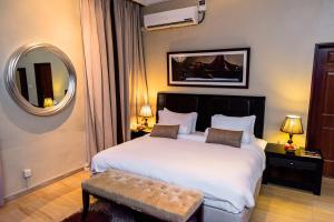 a hotel room with a large bed and a large mirror at Clear Essence California Spa & Wellness Resort in Lagos
